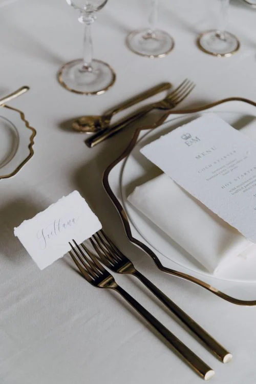 Wedding table styling inspiration with gold-coloured cutlery, plates and glasses; stock photograph, not XOXO inventory