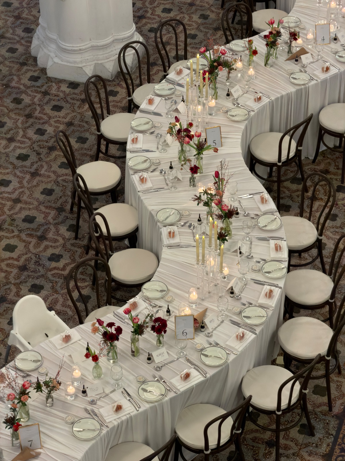 Styled event dining table with bentwood chairs and flowers